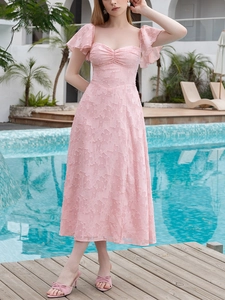 Détail de robe midi rose en jacquard à manches volantées en décor de vacances