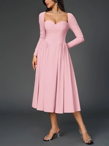 Détail de robe midi rose avec décolleté en cœur et coupe style corset ajustée