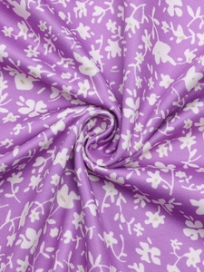 Vue macro du tissu floral violet avec imprimé blanc et texture de soie douce