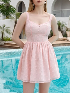 Detail of light pink sleeveless dress featuring textured jacquard fabric and waist buttons