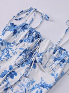 Détail de la robe à fleurs bleues avec décolleté plissé et fines bretelles à nouer