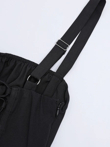 Detail view of adjustable spaghetti straps and side invisible zipper on a black midi dress