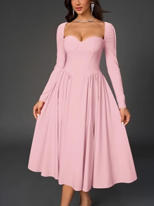 Détail d'une robe rose à manches longues avec décolleté en cœur et haut corset
