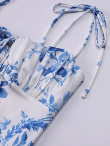 Détail de robe à fleurs bleues avec buste plissé et fines bretelles à nouer aux épaules