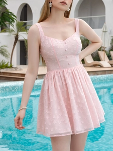 Close-up of pink jacquard mini dress featuring floral appliques and decorative buttons