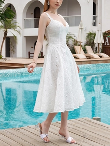 Detailed view of intricate white floral embroidery on a V-neck midi sundress fabric