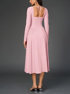 Détail d'une robe rose à manches longues avec dos nu et élégant nœud de serrage à l'arrière