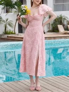 Détail d'une robe maxi en jacquard rose avec décolleté en cœur et fente haute