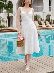 Close-up of white midi dress featuring intricate floral embroidery and a deep V-neckline