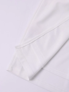 Macro shot of precise double-needle stitching and overlock seams on a white knit dress