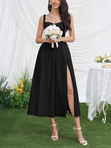 Detail of black slim fit midi dress featuring high slit and elegant spaghetti straps