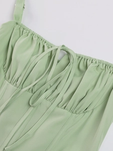 Detail of light green corset top with lace-up front and gathered bust texture