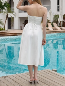 Detail of elegant white strapless midi dress featuring back drawstring ties and ruched fabric