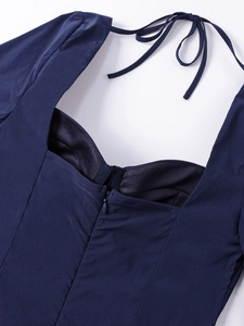 Détail de robe bleu marine avec bonnets intégrés, col carré et fermeture éclair au dos