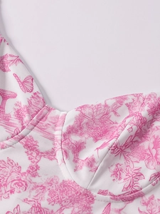 Dettaglio dell'abito in rete bianca con stampe floreali di farfalle e cuciture coppe