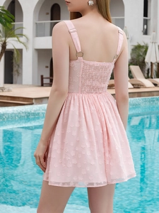 Macro shot of pink dress details showing 3D floral texture and elastic smocked back