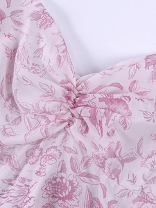 Détail de la robe fleurie rose en mousseline avec nœud torsadé et finitions plissées