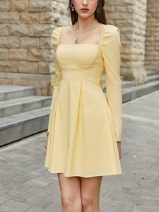 Detail of square neckline and puff sleeves on a pale yellow long sleeve mini dress