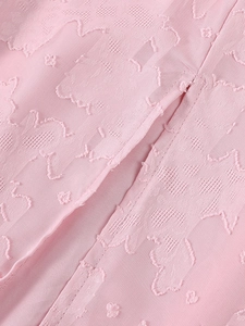 Gros plan détaillé du tissu jacquard rose avec textures florales et coutures fines
