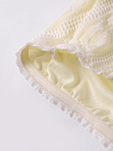 Détail du tissu tricoté jaune clair avec dentelle et bande de silicone antidérapante