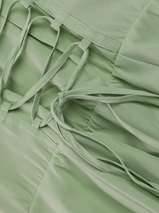 Detail of light green floral fishbone dress featuring lace-up crisscross tie design