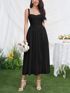 Close-up of black midi corset dress with boning detail and flowy pleated skirt