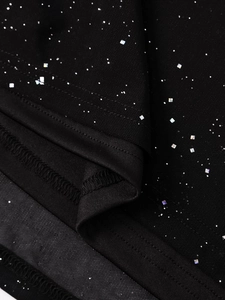 Vue macro du tissu en maille noire avec paillettes argentées et coutures de l'ourlet