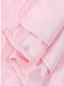 Gros plan détaillé de la robe rose avec broderie florale et texture de maille fine