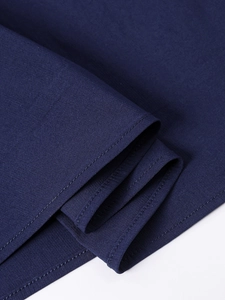 Gros plan sur l'ourlet de robe bleu foncé montrant une double couture de qualité et texture