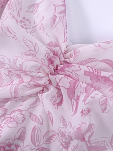 Détail du tissu en mousseline avec imprimé floral, design noué et motifs de fleurs roses