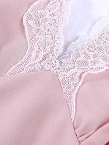Close-up of pink dress neckline featuring delicate white floral lace trim details