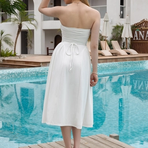 White strapless backless midi dress with lace-up tie detail on elegant resort background