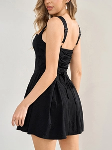 Détail du laçage au dos d'une mini robe en jacquard noir avec des boucles en métal