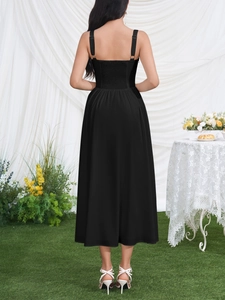 Rear view of black midi slip dress featuring ruched back detail and elegant A-line silhouette