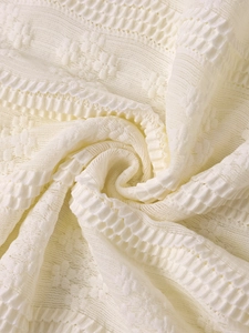 Gros plan sur la dentelle tricotée beige avec des motifs de tissage floraux plissés en 3D