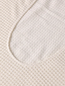 Detail of white waffle knit fabric texture and high-quality stitching on the neckline