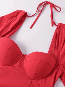 Détail d'une robe rouge dos nu trapèze avec lien licou et bonnet à armatures ajusté