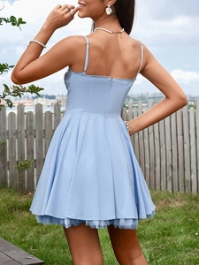 Detail of light blue corset dress showing delicate lace trim and layered mesh hemline