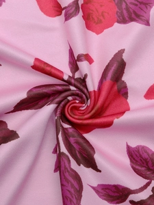 Vue détaillée du tissu floral rose avec roses rouges et texture de maille fine