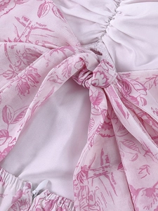 Détail de la robe en mousseline fleurie rose avec nœud papillon et fermeture éclair invisible