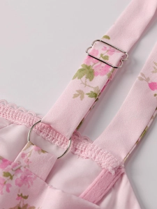 Detail of adjustable strap with metal buckle and lace trim on pink floral slip dress