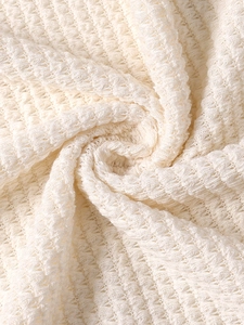Close-up detail showing the cream white waffle texture of the knitted beach maxi dress