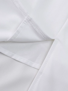 Close-up of white plain weave fabric showing detailed flatlock stitching and hem finish