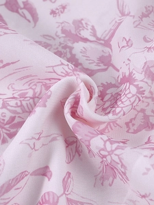 Vue détaillée du tissu en mousseline rose avec motif floral classique style toile de jouy