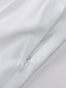 Detailed close-up of high-quality invisible zipper on a white twill fabric dress