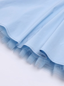 Detail of light blue dress hem featuring multi-layered tulle stitching and fine fabric texture