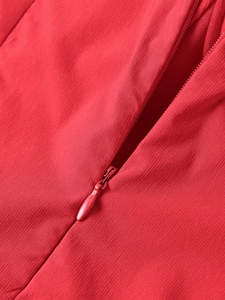 Vue détaillée d'une fermeture éclair invisible sur une robe rouge en tencel