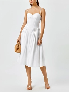 Détail d'une robe mi-longue blanche style corset avec bretelles et jupe trapèze fluide