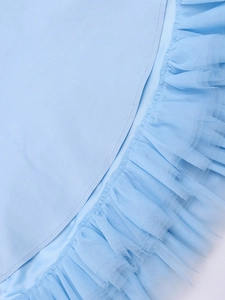 Detail of light blue dress showing multi-layered tulle ruffles and fine stitching craft