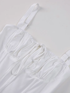Close-up detail of white corset dress featuring ruched chest design and tie-up front lacing